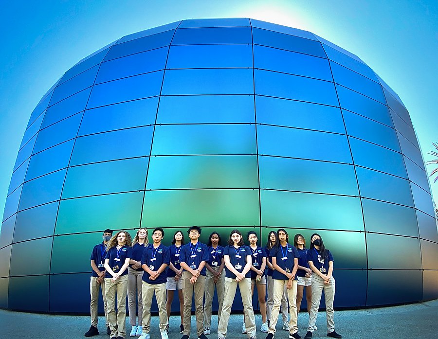 Group of teen volunteers pose in front of the Pacific Visions building