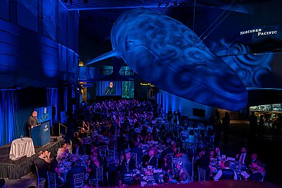 Dr. Peter Kareiva, Aquarium of the Pacific president and CEO, speaks during the 2022 Blue Whale Gala before guests sat at round tables underneath a life-size model of a blue whale - thumbnail