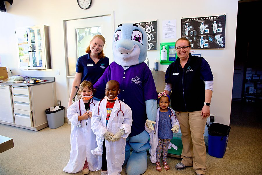 Aquarium staff and kids with costumed character