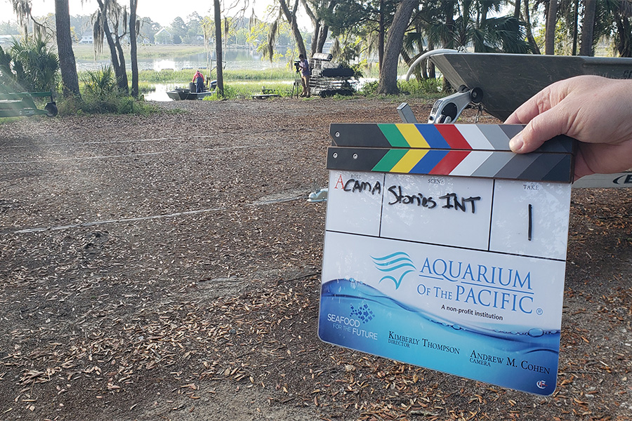 Clapboard with Aquarium and Seafood for the Future logos in foreground with South Carolina wetlands and farmer on boat in background. 900x600 gallery